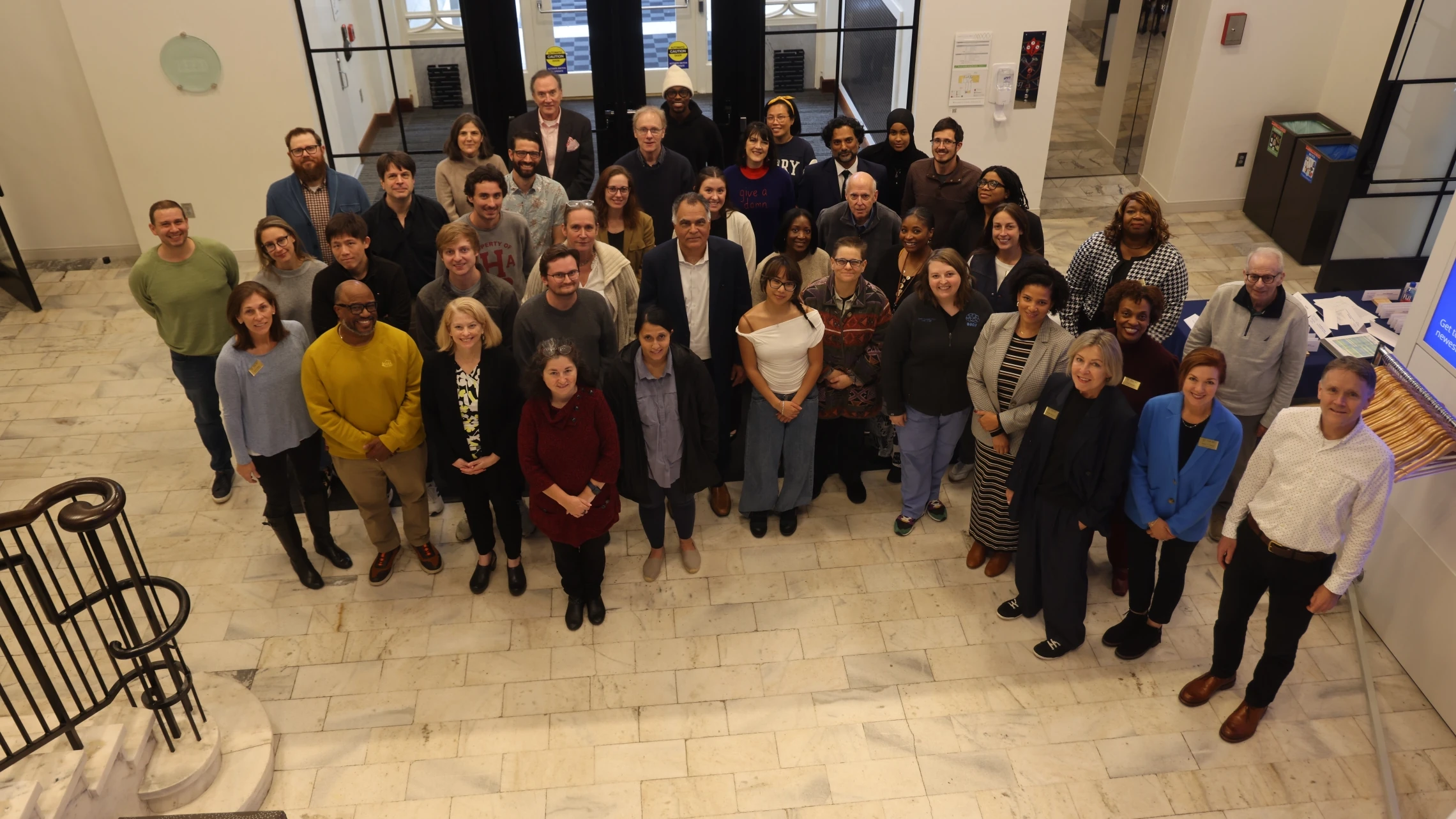 Overhead group photo of Emory University Senate meeting attendees gathered in the building lobby