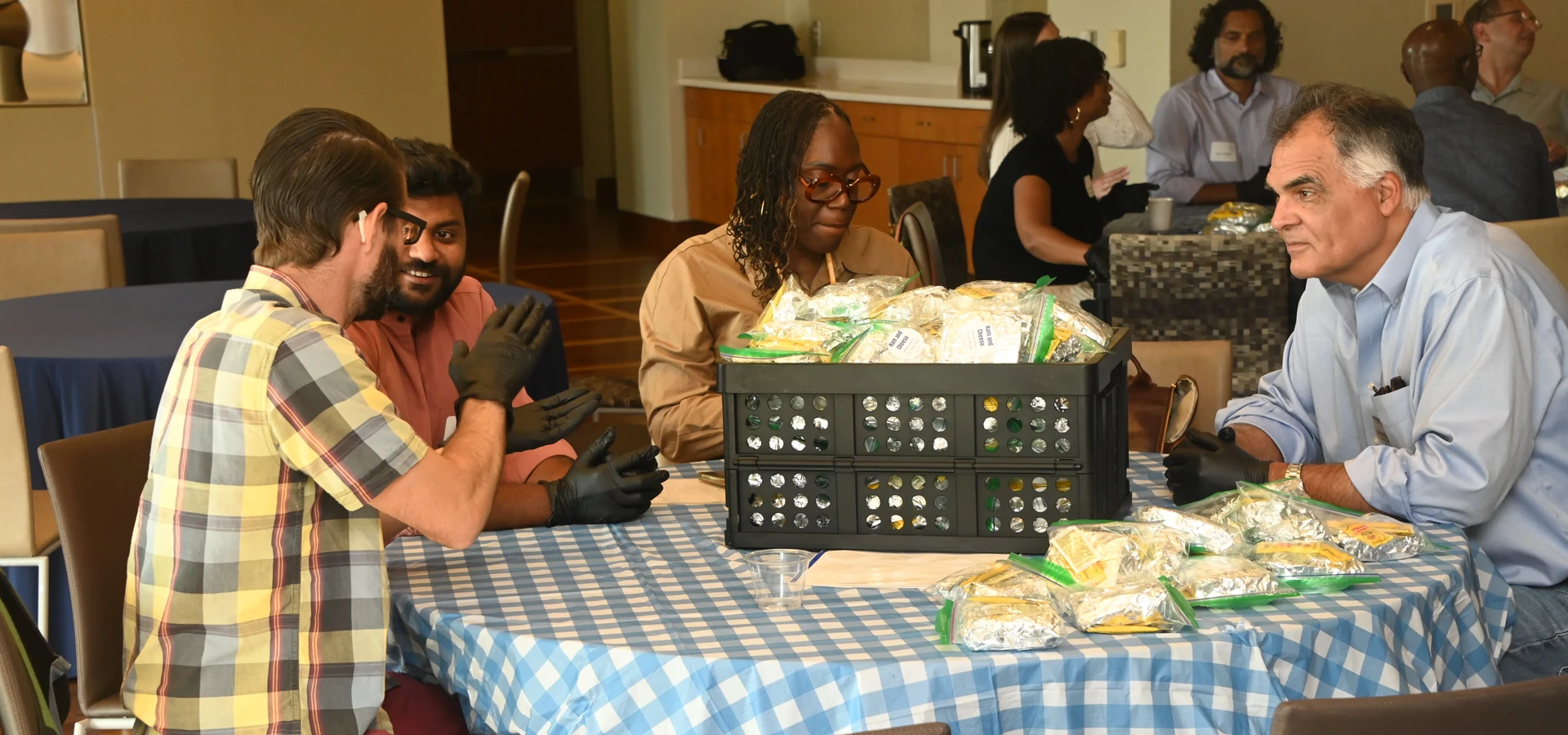 Senate members seated around a table preparing sandwiches during a community service activity