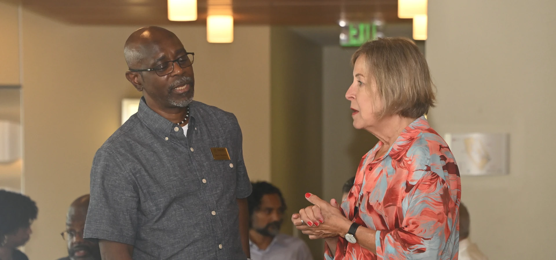 Two Senate members engaged in conversation during the orientation event